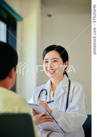 Young female doctor examining an elementary school boy 97020846