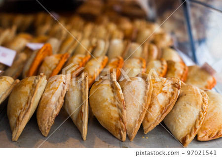 freshly baked empanadas with different fillings for sale 97021541