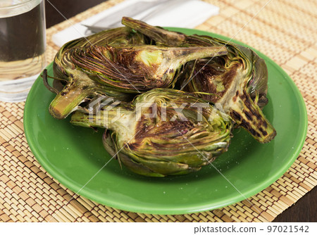 cooked fried halves artichokes on green plate 97021542