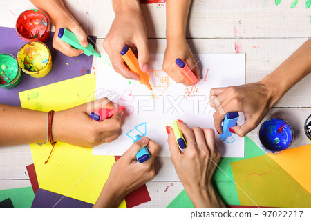 Markers in male and female hands draw on white paper 97022217