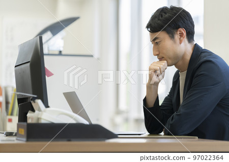 Businessman thinking while looking at the computer screen Profile 97022364