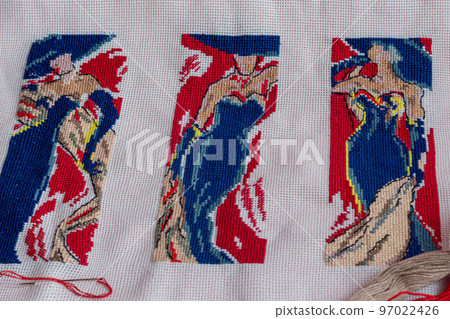 Handmade embroidery. Multicolored patterns on white fabric. Ethnic drawing. Handmade embroidery. Multicolored patterns on white fabric. Ethnic drawing. 97022426