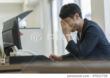 一個三十多歲的商人把頭靠在辦公桌前 一個三十多歲的商人把頭靠在辦公桌前 97022739