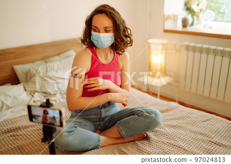 Woman blogger videotapes her vlog at home and speaking about Vaccine for covid-19. Woman blogger videotapes her vlog at home and speaking about Vaccine for covid-19. 97024813