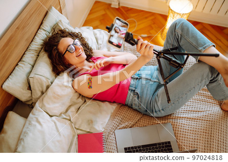 Woman blogger videotapes her vlog at home and speaking about Vaccine for covid-19. 97024818