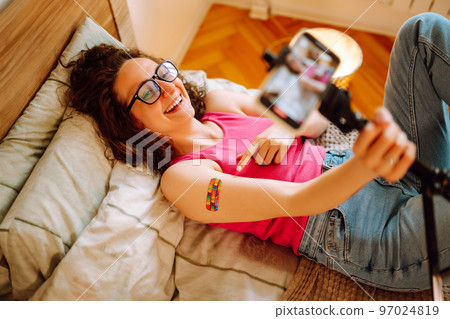 Woman blogger videotapes her vlog at home and speaking about Vaccine for covid-19. 97024819