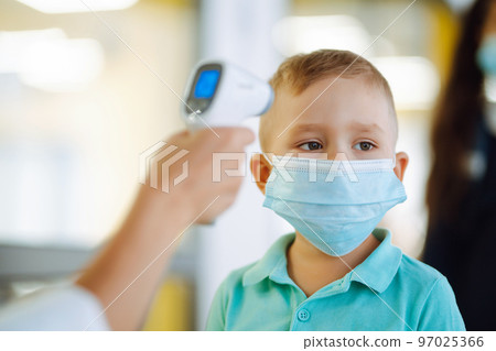 Nurse or doctor checks children body temperature using infrared forehead thermometer for virus. Nurse or doctor checks children body temperature using infrared forehead thermometer for virus. 97025366