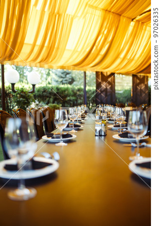 Sparkling glassware stands on long table prepared for wedding dinner. Sparkling glassware stands on long table prepared for wedding dinner. 97026335