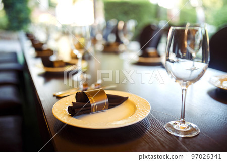 Sparkling glassware stands on long table prepared for wedding dinner. 97026341