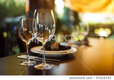 Sparkling glassware stands on long table prepared for wedding dinner. 97026342