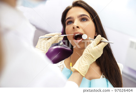 Overview of dental caries prevention. Woman at the dentist's chair during a dental procedure.. Healthy Smile. 97026404
