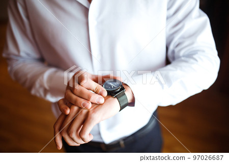 Stylish men's wrist watch, the man is watching the time. Businessman clock, businessman checking time on wristwatch. 97026687