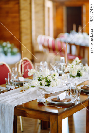 Beautiful table setting for a party, wedding reception or other festive event. Banquet setting, glasses, plates. Beautiful table setting for a party, wedding reception or other festive event. Banquet setting, glasses, plates. 97027470