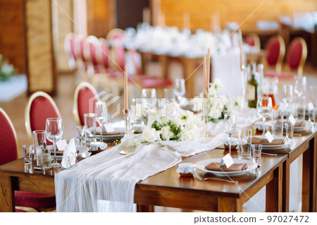Beautiful table setting for a party, wedding reception or other festive event. Banquet setting, glasses, plates. Beautiful table setting for a party, wedding reception or other festive event. Banquet setting, glasses, plates. 97027472