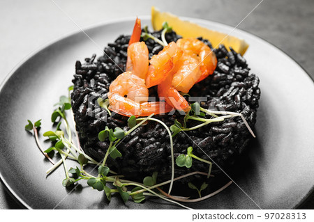 Delicious black risotto with shrimps on table, closeup Delicious black risotto with shrimps on table, closeup 97028313
