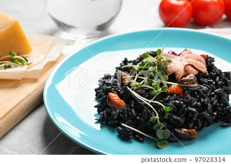 Delicious black risotto with seafood on table, closeup Delicious black risotto with seafood on table, closeup 97028314