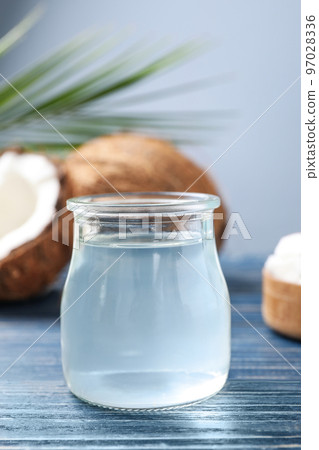 Coconut oil on blue wooden table, closeup view Coconut oil on blue wooden table, closeup view 97028336