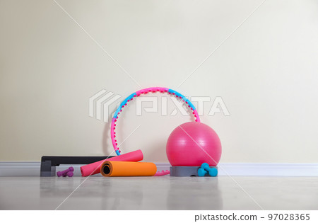 Different sports equipment near light wall in gym Different sports equipment near light wall in gym 97028365