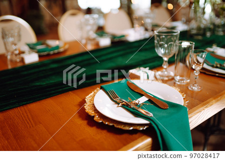 Banquet table in the restaurant, preparation before the banquet. The work of professional florists. Banquet table in the restaurant, preparation before the banquet. The work of professional florists. 97028417