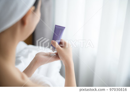 Close up of women applying body lotion cream on hand. 97030816