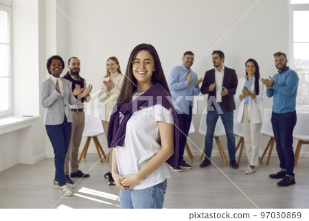 Portrait of confident happy young woman in casual clothes against background of other people. 97030869