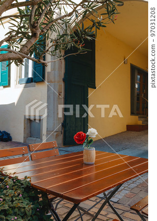 Empty cafe terrace with white table and chair. exterior of the cafe restaurant. interior Street cafe. Cozy street with flowers and French-style cafe table. Decor facade of coffeehouse with bike. Table 97031208