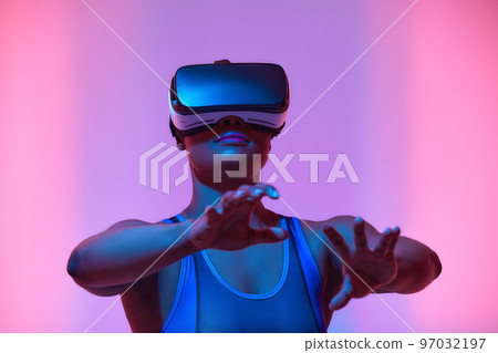 African american woman streamer playing video game using virtual reality glasses at gaming room 97032197