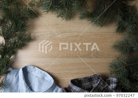 men's New Year's Christmas background. Shirt blouse new year hat santa and branches Christmas tree on a tree background with a place for text copyspace. Festive background 97032247