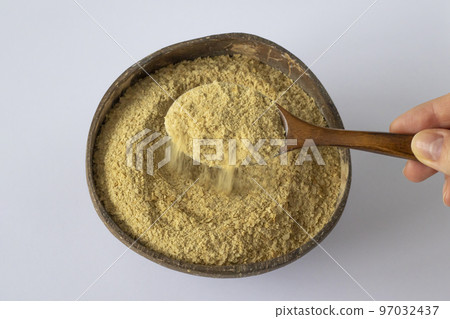 Nutritional yeast in a wooden bowl with spoon. Healthy vegan food concept. 97032437