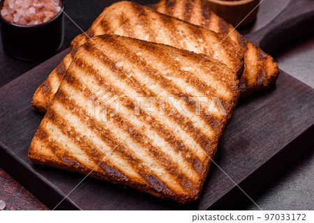 Tasty fresh crispy bread slices in the form of grilled toast Tasty fresh crispy bread slices in the form of grilled toast 97033172