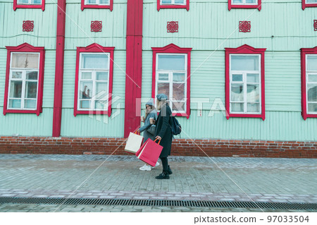 Happy female friends shopping. Two beautiful young women enjoying shopping in city with shopping bags copy space - consumerism and friendship concept 97033504