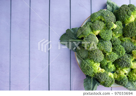 Broccoli inflorescences on a plate, top view, space for text. Green fresh cabbage Broccoli inflorescences on a plate, top view, space for text. Green fresh cabbage 97033694