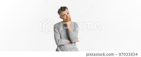 Portrait of bored and unamused middle-aged man in grey sweater, leaning on hand and looking at camera reluctant, standing sad over white background 97033834