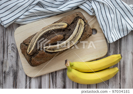Crunchy cinnamon banana bread on a wooden background with a napkin and fresh ripe bananas. A sugar free and gluten free meal. 97034181