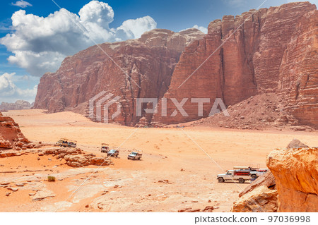 Orange sands and rocks of Wadi Rum desert with bedouin cars in the foreground, Jordan Orange sands and rocks of Wadi Rum desert with bedouin cars in the foreground, Jordan 97036998