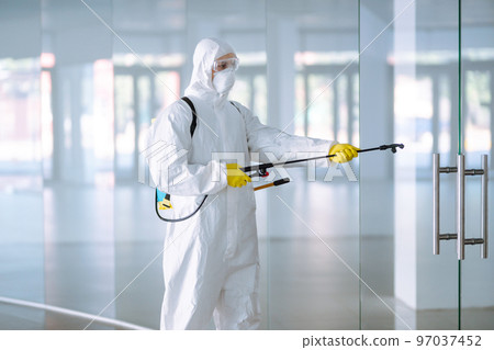 Disinfecting of office to prevent COVID-19, Man in protective hazmat suit with with spray chemicals. Disinfecting of office to prevent COVID-19, Man in protective hazmat suit with with spray chemicals. 97037452