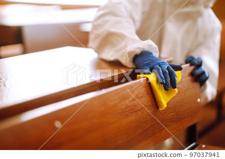 Cleaning and disinfection school desk during coronavirus pandemic. COVID-19. 97037941