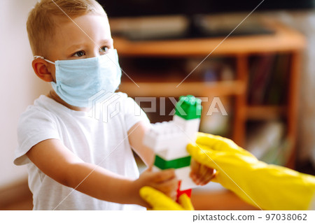Little boy and mom in medical mask. Mother puts on her baby sterile medical mask. Wearing face mask. 97038062