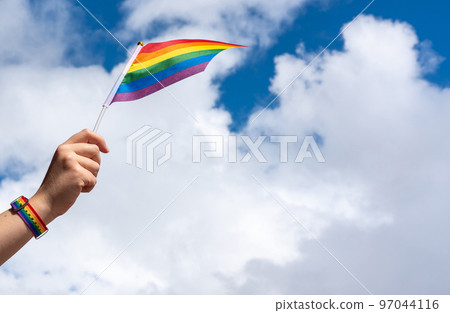 Waving LGBT flag in a female hand and space for an inscription Waving LGBT flag in a female hand and space for an inscription 97044116