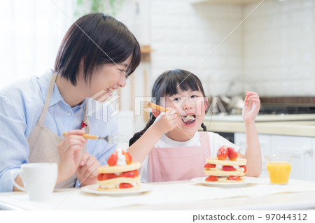 Family girls and moms eating panques Family girls and moms eating panques 97044312