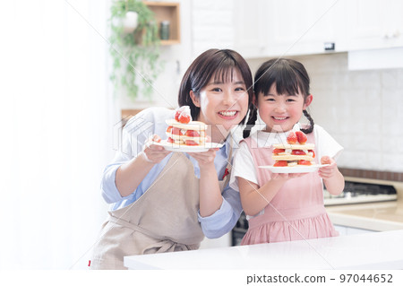 一個女孩和一個做煎餅的媽媽 一個女孩和一個做煎餅的媽媽 97044652
