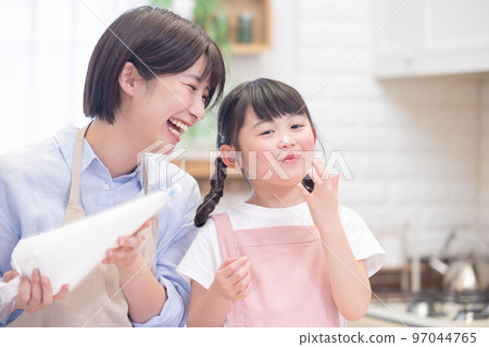 一個女孩和一個做煎餅的媽媽 97044765