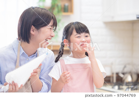 一個女孩和一個做煎餅的媽媽 97044769
