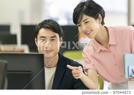 辦公室工作圖像 兩個商務人士,一男一女,一邊看著 PC 顯示屏一邊聊天 辦公室工作圖像 兩個商務人士,一男一女,一邊看著 PC 顯示屏一邊聊天 97044873