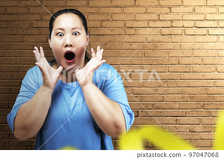 Asian fat overweight woman with a shocked expression Asian fat overweight woman with a shocked expression 97047068