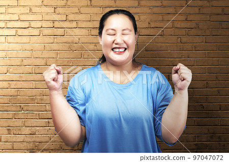 Asian fat overweight woman with an excited expression Asian fat overweight woman with an excited expression 97047072