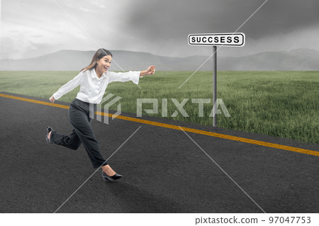 Asian businesswoman running on the street with a success sign Asian businesswoman running on the street with a success sign 97047753