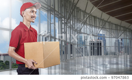 Parcel delivery man with a hat carrying a package 97047863