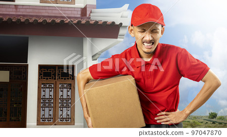 A parcel delivery man with a hat feels a stomachache while carrying a package A parcel delivery man with a hat feels a stomachache while carrying a package 97047870