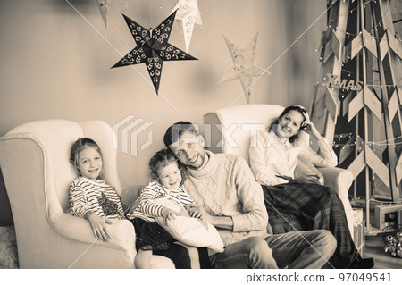 happy family sitting in the living room Christmas evening. black and white photo happy family sitting in the living room Christmas evening. black and white photo 97049541